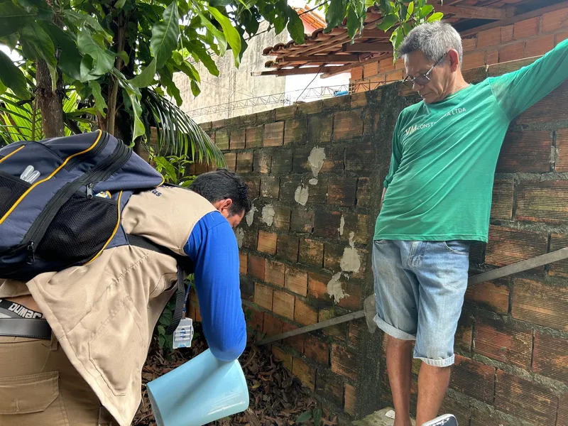 O morador Raimundo Donato observa a forma correta de eliminar a água parada para evitar focos do mosquito.