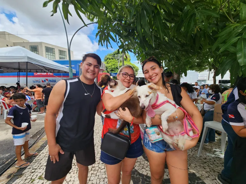 O gatinho Tom e a cadela Dora, acompanhados de seus tutores, o educador físico Vinícius Barbosa e a estudante Giovana Souza, foram até a praça para garantir a vacinação. <div class='credito_fotos'>Foto: Ascom Sesma | <a href='/midias/2025/originais/9742664d-bd86-4cd9-9e70-412d019478a3.jpg' download><i class='fa-solid fa-download'></i> Download</a></div>